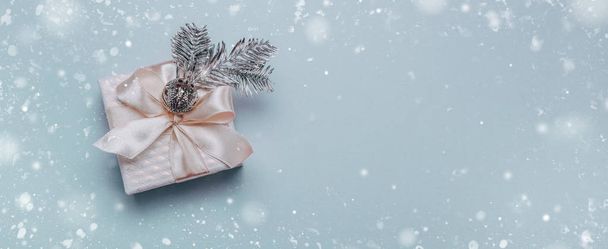 Vánoční kompozice.Malá dárková krabička s vánoční výzdobou, smrková stříbrná větev na světle modrém pozadí. Minimalismus, plochá lež. Nápis - Fotografie, Obrázek