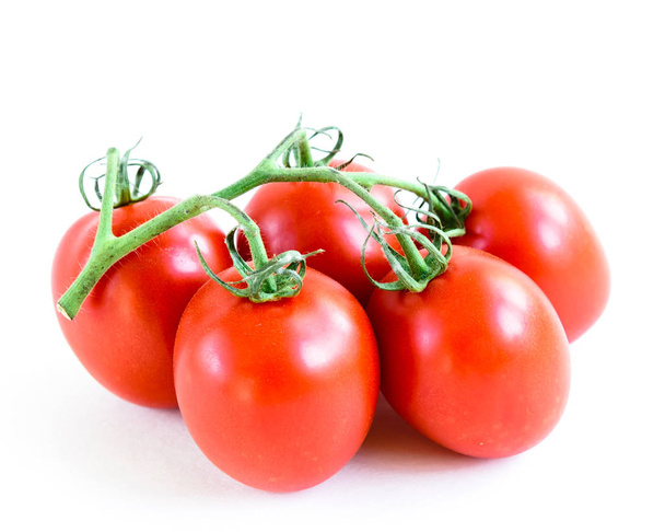Five on the vine Roma tomatoes isolated on white background. Cluster of vine ripened fruits still attached to the stems. Organic tomatoes with clipping path and copy space - Foto, Imagem