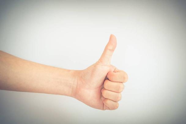 Vintage tone Asian male hand showing thumbs up sign against white background. Full arm man with gesture - Photo, Image