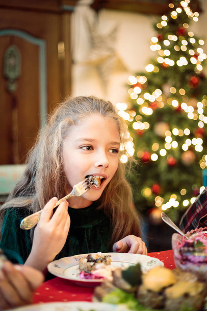 Little girl, teen daughter at a festive Christmas or New Year table. - Foto, Imagen