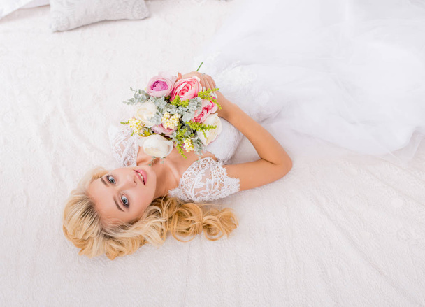 手に花束でポーズウェディングドレスの美しさの花嫁 - 写真・画像
