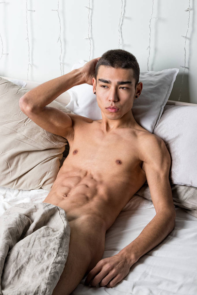 Young handsome man rest in bed. Sexy naked guy is resting - Foto, Imagen