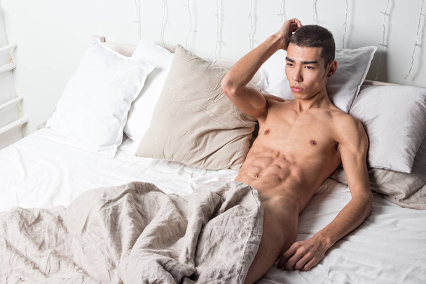 Young handsome man rest in bed. Sexy naked guy is resting - Foto, Imagem