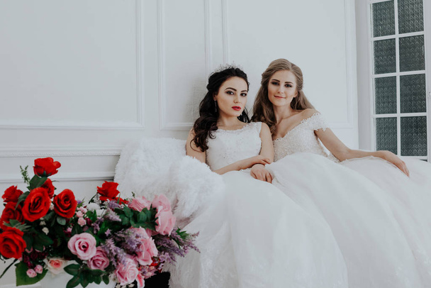 Esküvő-két fiatal nő portréja ruha fehér csarnokban - Fotó, kép