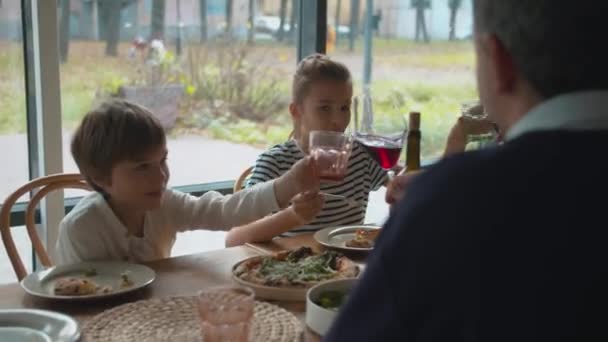 Los padres tintinean vasos con su hijo y su hija
 - Metraje, vídeo