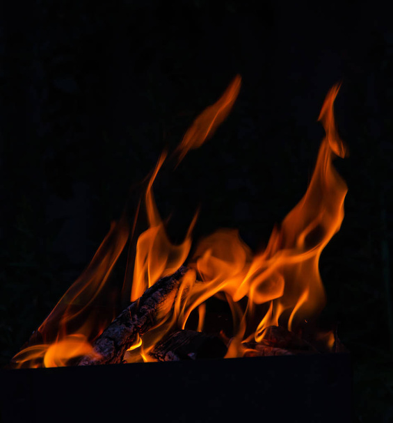 Chama vermelha, queima de madeira, dando calor e luz sobre um fundo preto
 - Foto, Imagem