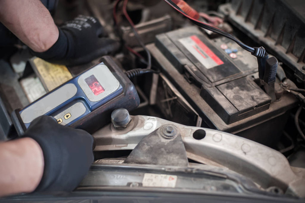 Automonteur controleren en testen van auto accumulator met ba - Foto, afbeelding