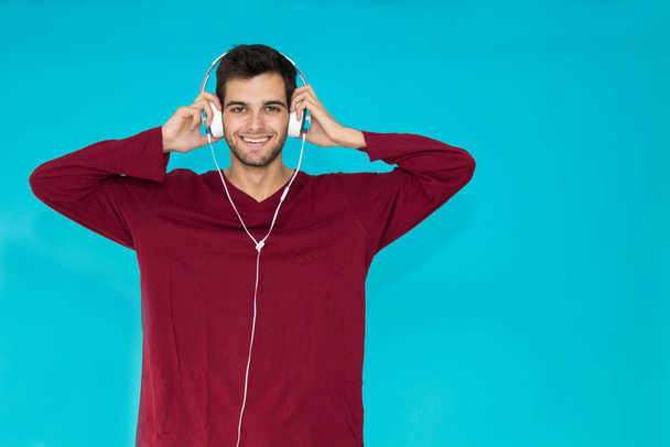 νεαρός άνδρας με ακουστικά απομονώνονται στο φόντο χρώμα - Φωτογραφία, εικόνα