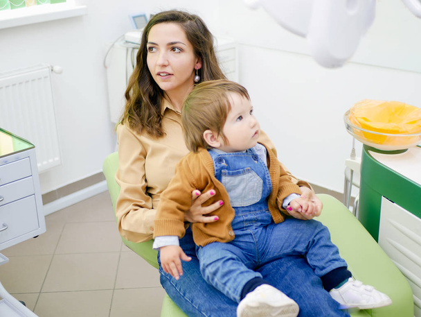 Dítě na matčině klíně na schůzce se zubaři. Dětský zubař. - Fotografie, Obrázek