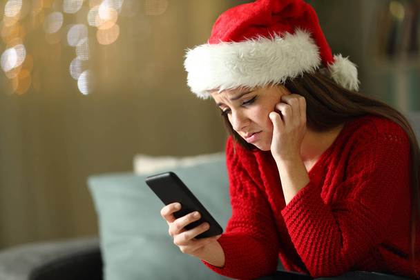 Sad woman checking phone on christmas holidays - Foto, imagen