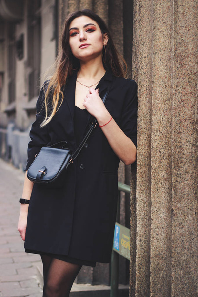 Model in zwarte jurk en lange jas. Stijl. Modetrends 2020 - Foto, afbeelding