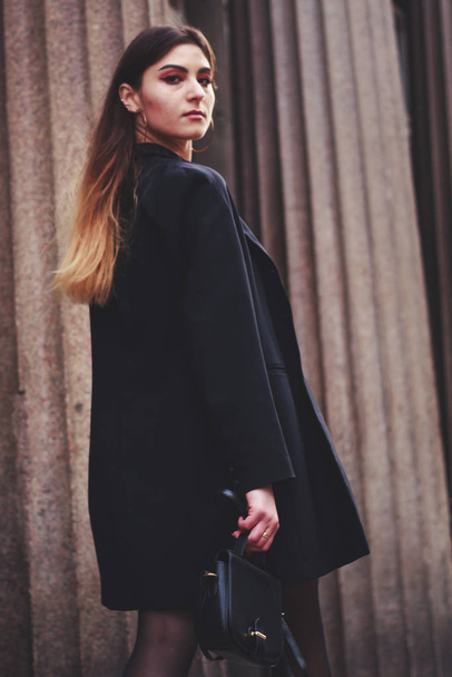 Siyah elbiseli ve uzun ceketli bir manken. Tarz. Moda eğilimleri 2020 - Fotoğraf, Görsel