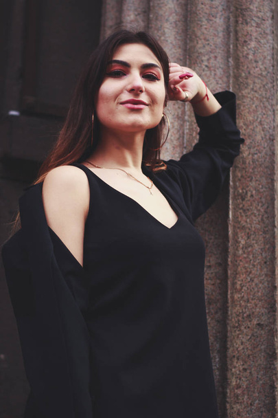 Model in zwarte jurk en lange jas. Stijl. Modetrends 2020 - Foto, afbeelding