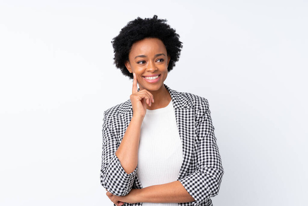 African american woman with blazer over isolated white background thinking an idea while looking up - Foto, Bild