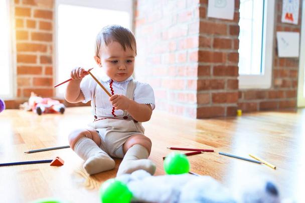 Schattige peuter spelen rond veel speelgoed op de kleuterschool - Foto, afbeelding