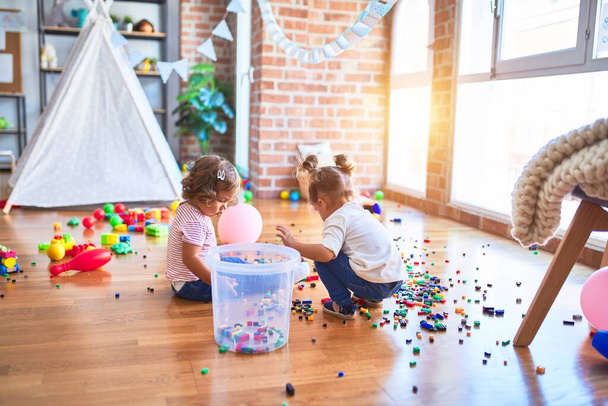 Adorable toddlers playing with building blocks toy at kindergarten - Photo, Image