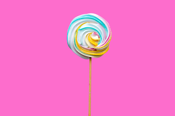 Paleta de caramelo para niños y adultos en palo de madera sobre fondo rosa. Chupando dulces para las vacaciones, confitería de azúcar
. - Foto, imagen