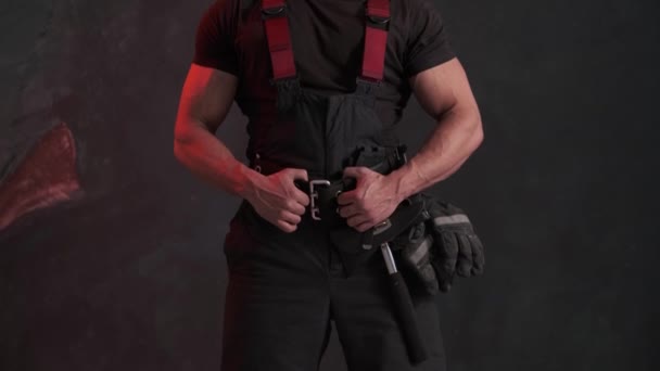 Statečný muž v hasičské uniformě stojí u šedé zdi a dívá se stranou - Záběry, video