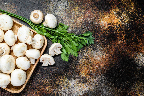 mushroom champignon in a bamboo bowl. Dark background. Top view. Space for text - Photo, Image