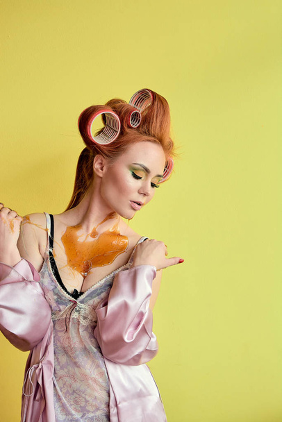 Young redhead woman with shugaring paste on her hands, face, body and chest. Young redhead woman with hair curlers. Advertising concept of shugaring paste. Skin care concept with copyspace. - Fotoğraf, Görsel