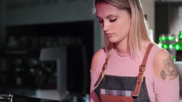 Gyönyörű fiatal lány eladó csomagok sütemények áll a pultnál a cukrászda áruház - Felvétel, videó