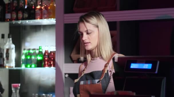 Kaunis nuori naismyyjä palvelee ostajaa makeiskaupassa
 - Materiaali, video