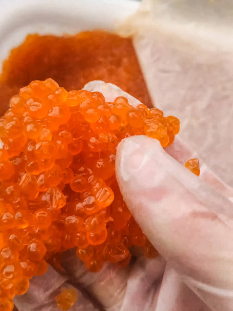 プラスチック製の容器に赤いキャビア鮭のキャビア、食事. - 写真・画像