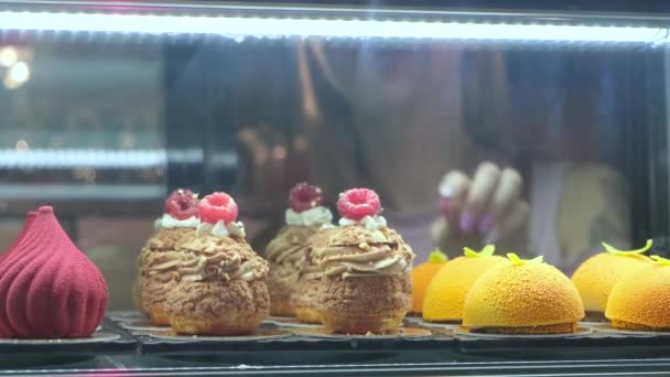 Gros plan de gâteaux appétissants couchés sur la vitrine dans la confiserie
 - Séquence, vidéo