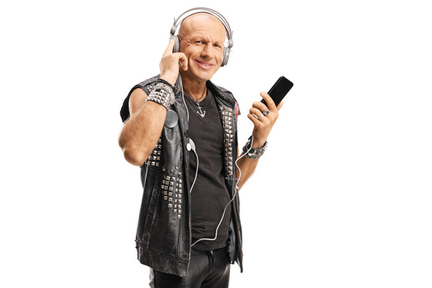 Bald punk wearing leather vest listening to music with headphone - Zdjęcie, obraz