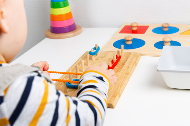 Dítě pracuje s materiálem Montessori pro jemné motorické dovednosti, sens - Fotografie, Obrázek
