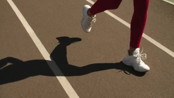 Close-up vrouwelijke voeten die op het stadion lopen. Vrouw hardloper joggen op de rails - Video