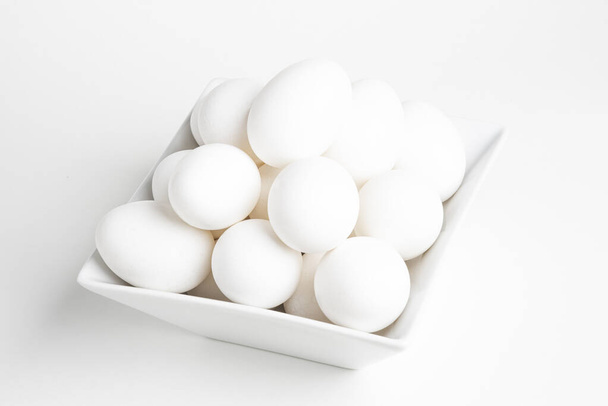 Tuoreet valkoiset munat Piled White Square Bowl
 - Valokuva, kuva