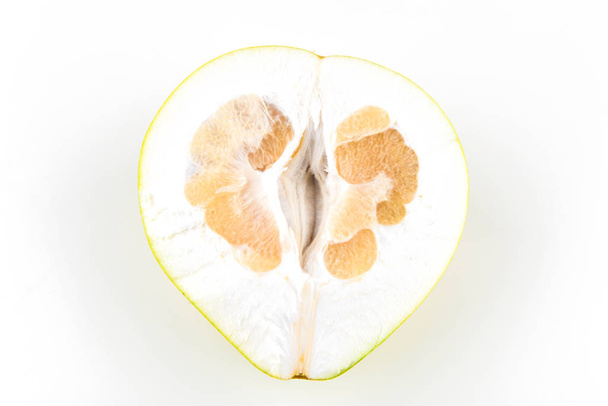 cut pomelo on a white background. Unripe. Small inside. Place for an inscription. Easy cut. View from above. close-up. - Photo, Image