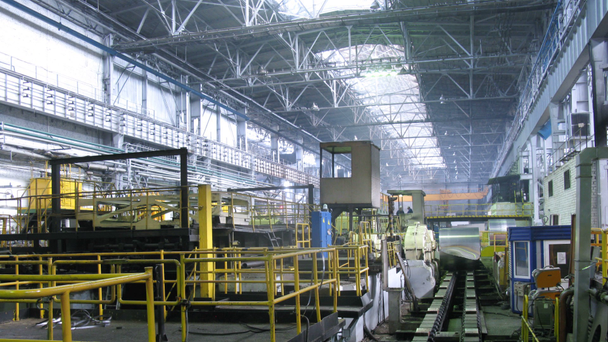 Жовтий кран рухається зверху у виробничому цеху прокатного заводу
 - Кадри, відео