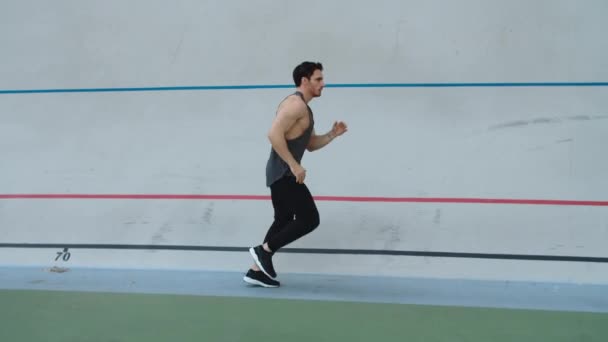Спортсмен біжить у повільному русі на трасі. Чоловік біжить на легкій атлетичній трасі
 - Кадри, відео