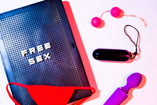 Red gstring  and sex toys on a pink background with a letterbox  - Photo, Image