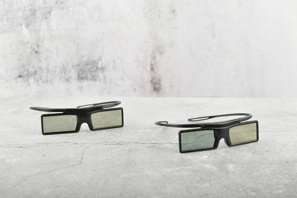 具体的な背景に黒い眼鏡。灰色のコンクリートの背景に3Dメガネの2組。トップビュー、コピースペース。灰色のコンクリートの背景に3Dメガネの2組。トップビュー、コピースペース  - 写真・画像