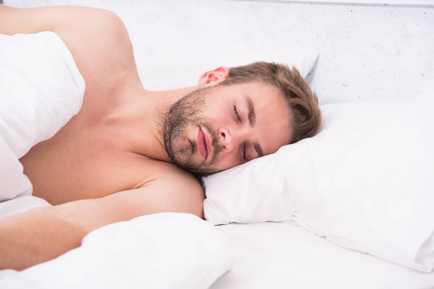 Circadian rhythm regulates sleep wake cycle. Man handsome unshaven guy in bed. Enough amount sleep every night. Tips sleep better. Bearded man relaxing on pillow. Soft pillow. Health care concept - 写真・画像