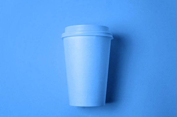 Simply flat lay design paper coffee cup colored in trendy color of year 2020 Classic Blue background. Bright Macro using color 19-4052. Top view copy space - Photo, Image