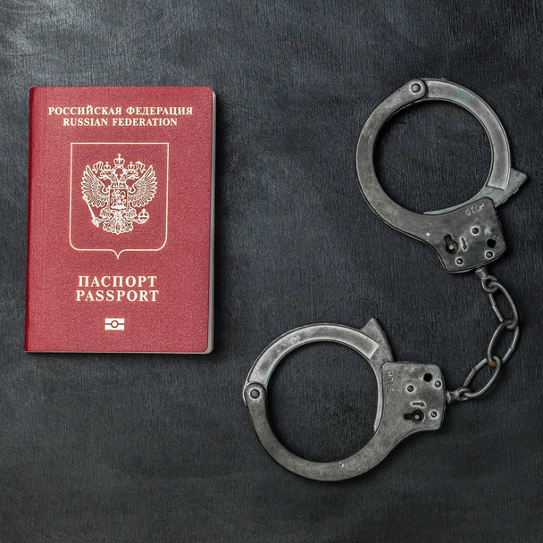 Російський паспорт з наручниками на чорному тлі - Фото, зображення