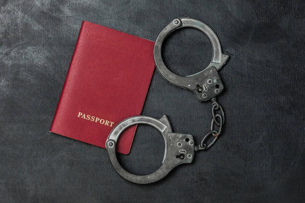 Паспорт з наручниками на чорному тлі
 - Фото, зображення