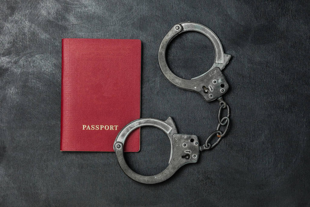Паспорт з наручниками на чорному тлі
 - Фото, зображення
