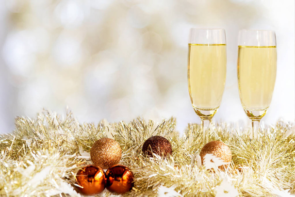 Mutlu noeller. Şampanya iki bardak kutlama ve evde Noel partisi. Sarı bokhe arkaplanı - Fotoğraf, Görsel