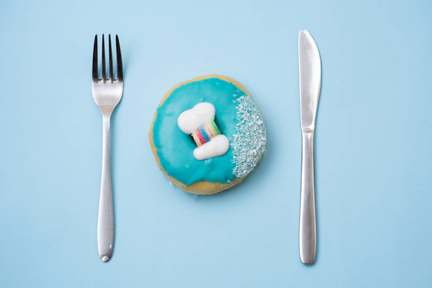 Flat lay of donut on blue background - Foto, afbeelding