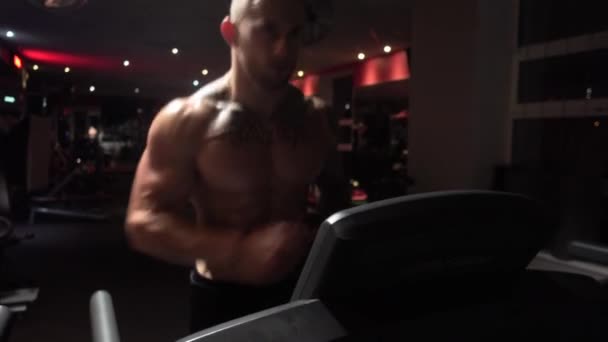 Fit guy in gym on treadmill - Кадры, видео