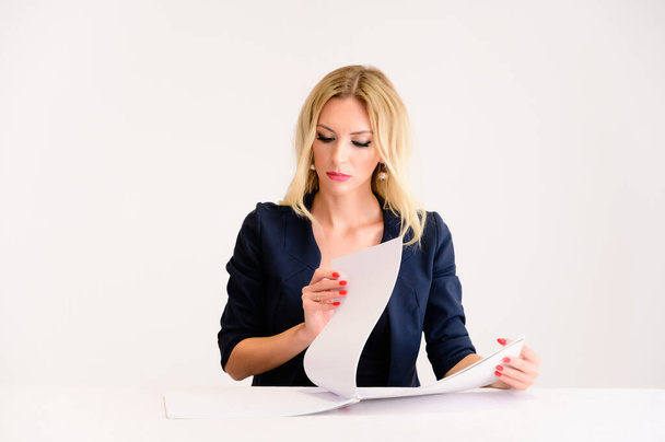 Business work concept. Portrait of a pretty woman accountant - financier with excellent makeup, beautiful hair on a white background sitting at a table with a folder in her hands. - Foto, Imagen