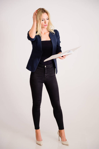 Business work concept. Full-length portrait of a pretty woman accountant - financier with excellent make-up, beautiful hair on a white background standing with a folder in her hands. - 写真・画像