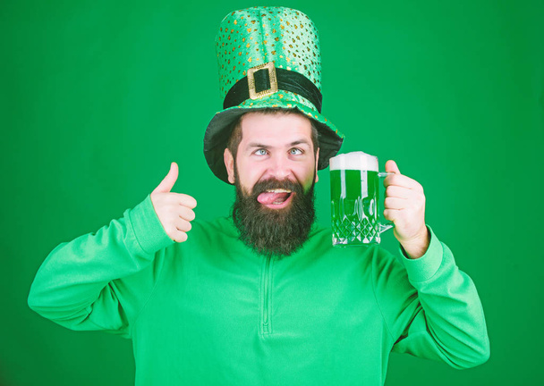 Highly recommend. Drinking beer celebration. Fest and holiday menu. Dyed green traditional beer. Patricks day party. Alcohol beverage. Symbol of Ireland. Man bearded hipster drink beer. Irish pub - Φωτογραφία, εικόνα