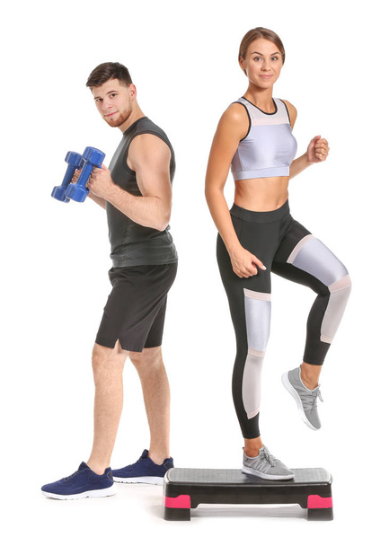 Sporty young couple with dumbbells and stepper on white background - Fotografie, Obrázek