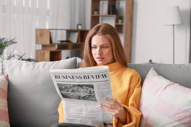 Jonge vrouw die thuis krant leest - Foto, afbeelding